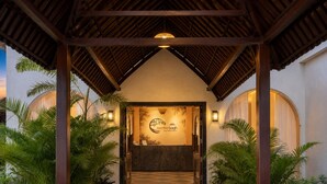 A covered entrance with a reception desk, palm trees, and a sign for 'Bambara Bah.' - Aamba Bagh Resort Kumbhalgarh  (Kumbhalgarh)