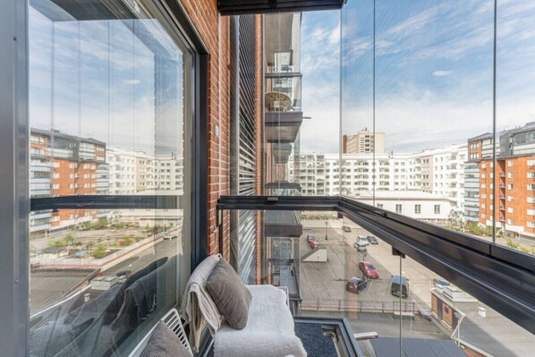 A high-rise apartment with a view of surrounding buildings and a parking area below.