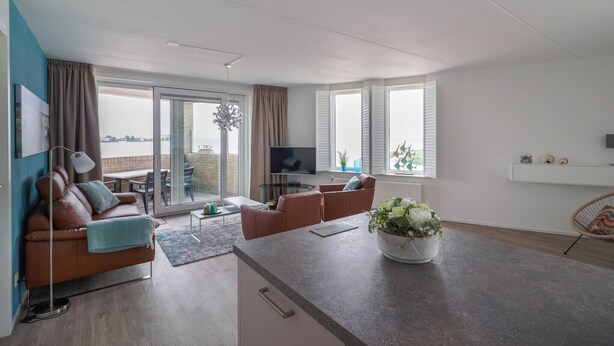 Una sala de estar moderna con un sofá, una mesa de centro y un televisor.