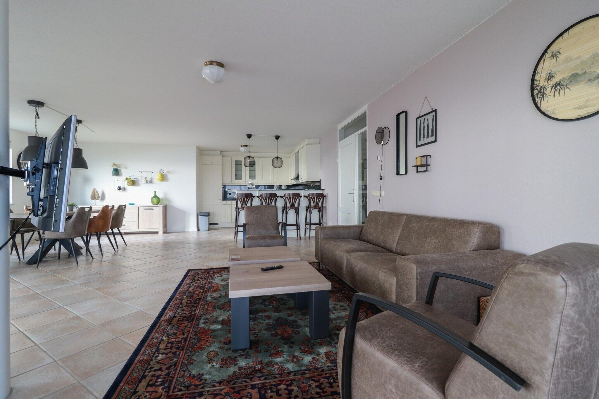A modern living room with a sofa, a coffee table, and a dining area with chairs.