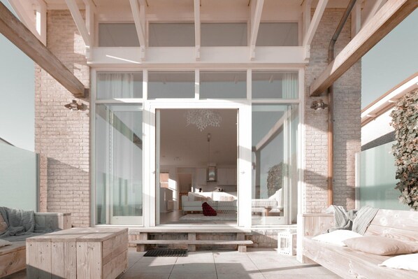 Ein modernes Interieur mit Glastür zum Wohnbereich, inklusive Sofa und Katze.