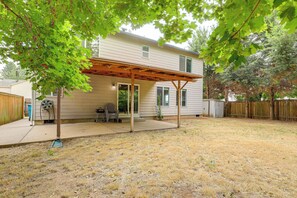 Einbungalow mit überdachter Terrasse, einem eingezäunten Garten und einer Holzterrasse.
