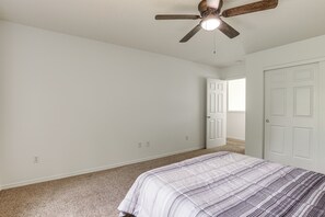 Un dormitorio con cama, ventilador de techo y puerta que da a otra habitaci ón.