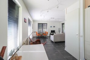 A modern interior with a dining area, sofa, and a TV. - Waterfront Beach Villa for 5 (Makkum)