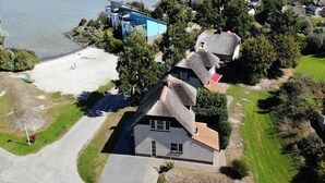 Una vista aerea di una zona residenziale con case, una spiaggia e un corpo d'acqua.