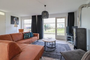 Ein Wohnzimmer mit einer Couch, einem Couchtisch, einem Fernseher und einem Kühlschrank.