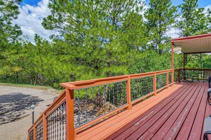 A wooden deck with a railing, a covered seating area, and a sign that reads 'The Porch.'