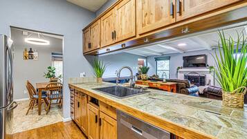 A kitchen with wooden cabinets, a granite countertop, and a dishwasher.