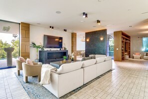 Ein geräumiges Wohnzimmer mit einer großen Couch, einem Couchtisch und einem flachbildfernseher an der Wand.