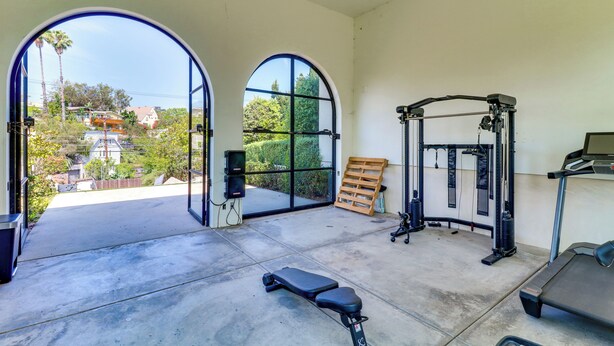 A home gym with a treadmill, weight bench, and exercise equipment. - 6,000-Sq-Ft Hollywood Hills Home w/ Pool, Hot Tub (Los Angeles)
