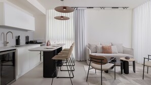 Une cuisine moderne dotée d’un îlot central, un coin repas avec un canapé et des chaises, et un espace de détente avec une table basse.