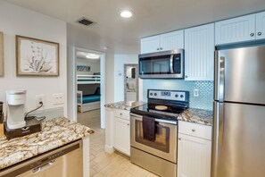 A modern kitchen with a built-in microwave, stainless steel refrigerator, and a coffee maker. - Unwind Poolside, Walk to Shore! Ponce Inlet Escape (Ponce Inlet)