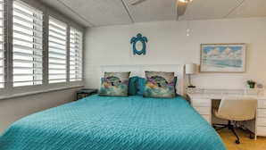 A bedroom with a large bed, a desk, and a chair. - Unwind Poolside, Walk to Shore! Ponce Inlet Escape (Ponce Inlet)
