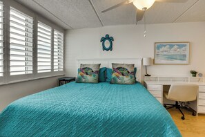 A bedroom with a large bed, a desk, and a chair. - Unwind Poolside, Walk to Shore! Ponce Inlet Escape (Ponce Inlet)