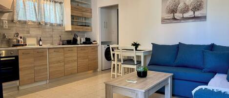 Un appartement moderne comprenant une cuisine, un coin repas et un salon.