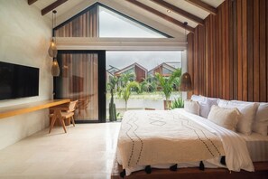 A modern bedroom with a large bed, a desk, and a TV. - 1 BR Beachside Retreat Blacksand Villas Bingin (Badung)