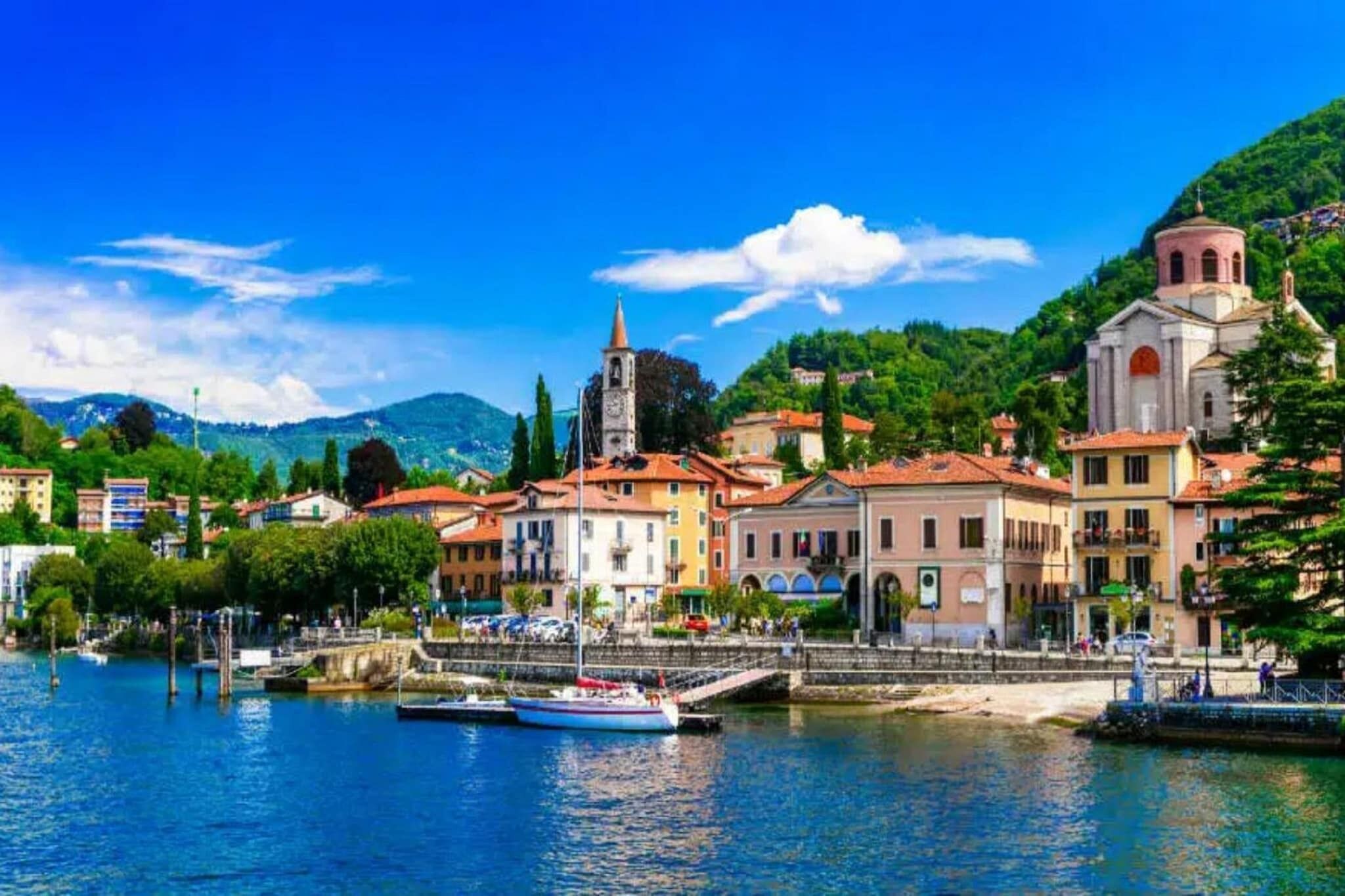 A waterfront town with buildings, a church, and boats.