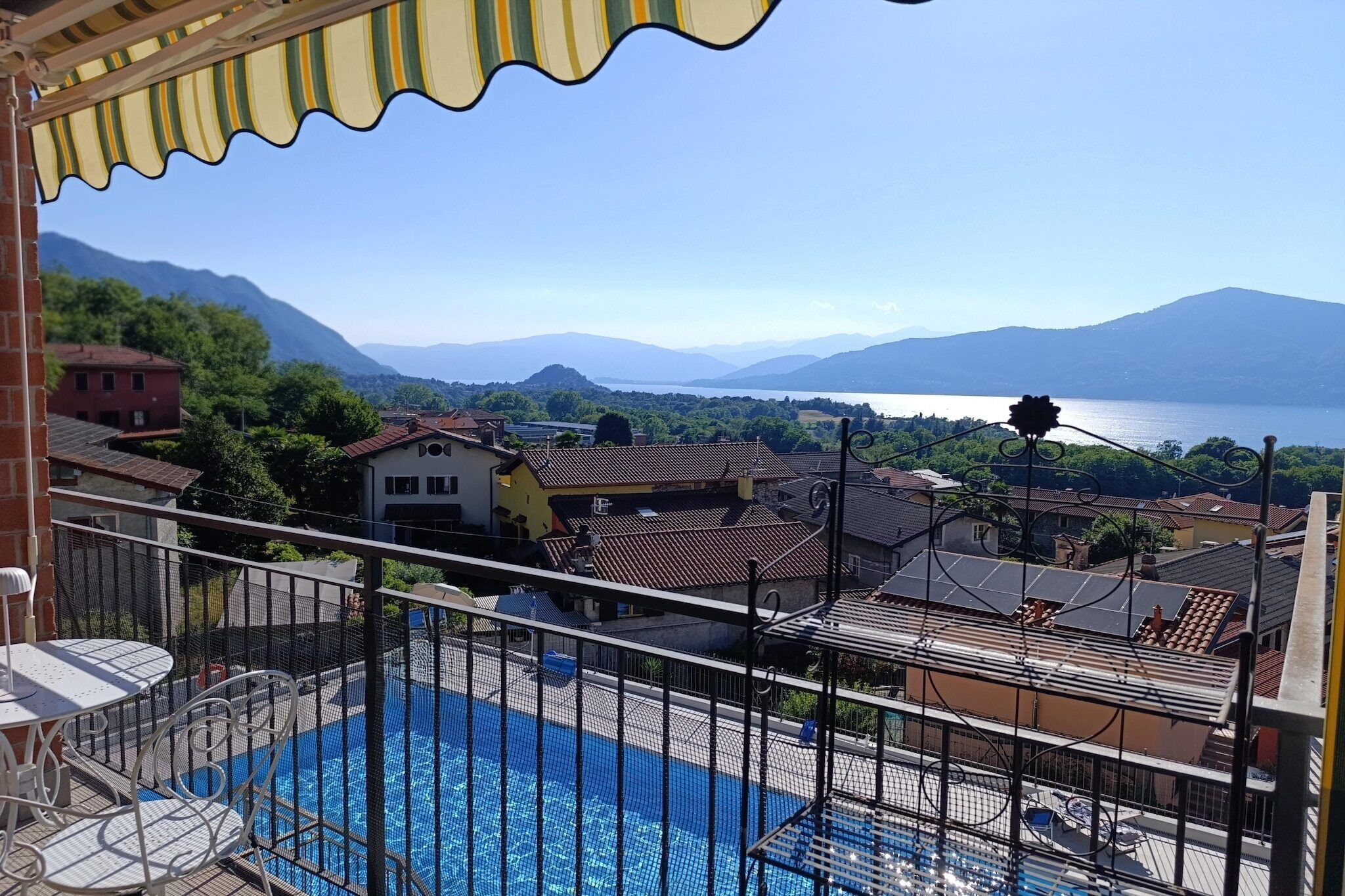 A pool area with a view of a lake and mountains.