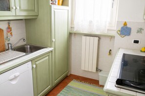 A kitchen with a sink, a stove, and cabinets. - Lakeside Apartment in Germignaga for 4 (Germignaga)