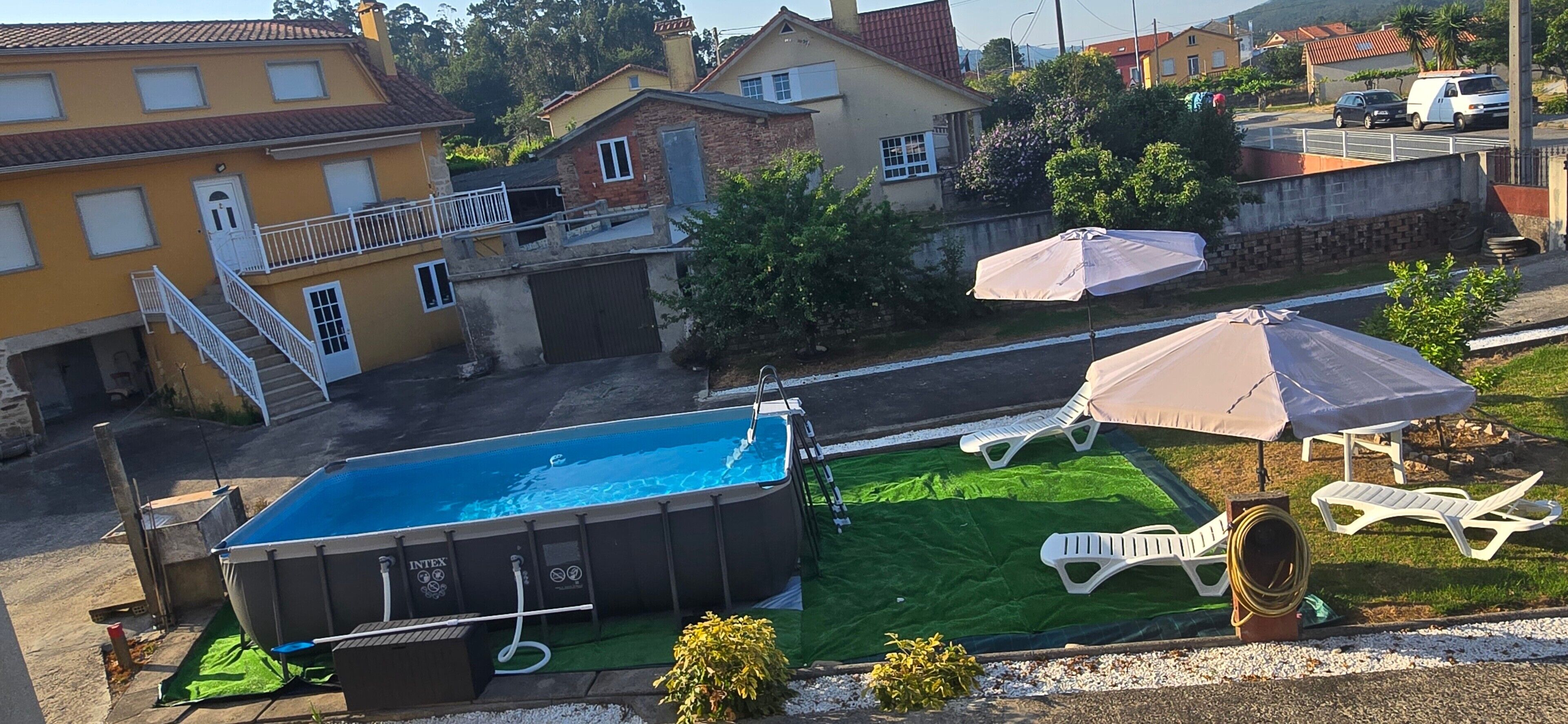 Et boligområde med swimmingpool, udendørs møbler og huse.