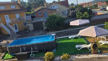 Et boligområde med swimmingpool, udendørs møbler og huse.