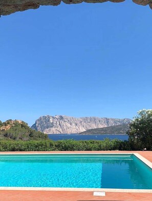A swimming pool with a view of a mountainous landscape and a body of water. - Punta Est - PERLA Two-Bedroom Apartment with Terrace and Ocean View (Capo Coda Cavallo)