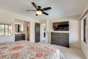 A bedroom with a bed, a dresser, a ceiling fan, a TV, and a door leading to another room. - 2 Mi to Lake Havasu! Mtn-View Poolside Paradise (Lake Havasu City)