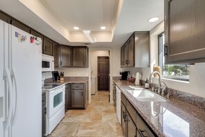A modern kitchen with granite countertops, stainless steel appliances, and a large window providing natural light. - 2 Mi to Lake Havasu! Mtn-View Poolside Paradise (Lake Havasu City)