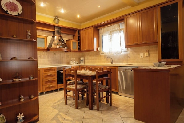 A kitchen with wooden cabinets, a central island, a built-in oven, and a dishwasher.