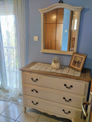 A room with a wooden dresser, a mirror, and a lace doily.