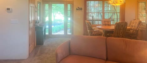 Un salon comprenant un canapé, une table à manger, des chaises et un lustre.