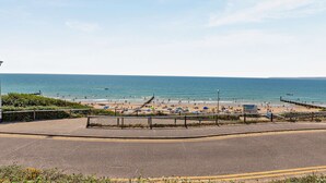Eine Küstenstraße, die zu einem Strand führt, mit freiem Blick auf das Meer.