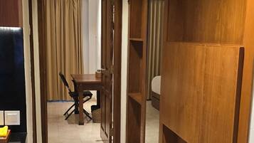 A hotel corridor with a dining area, wooden paneling, and a trash bin.