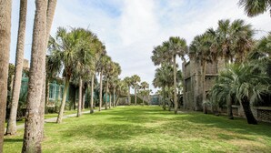 A courtyard with palm trees and a brick building. - 1 BR Ocean Inlet View with Private Pool (Murrells Inlet)