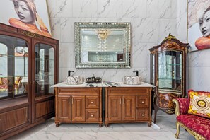 A marble-floored room with a large mirror, wooden cabinets, and a red upholstered sofa. - Oceanfront DeBordieu Estate, Direct Beach Access (Georgetown)