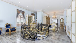 Ein luxuriöses Interieur mit Marmorböden, aufwendigen Möbeln und einem prunkvollen Kronleuchter.