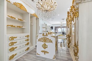 Ein luxuriöses Interieur mit aufwendigen Goldverzierungen, einer prunkvollen Chandelier und einem gut beleuchteten Flur, der zu einem Badezimmer führt.