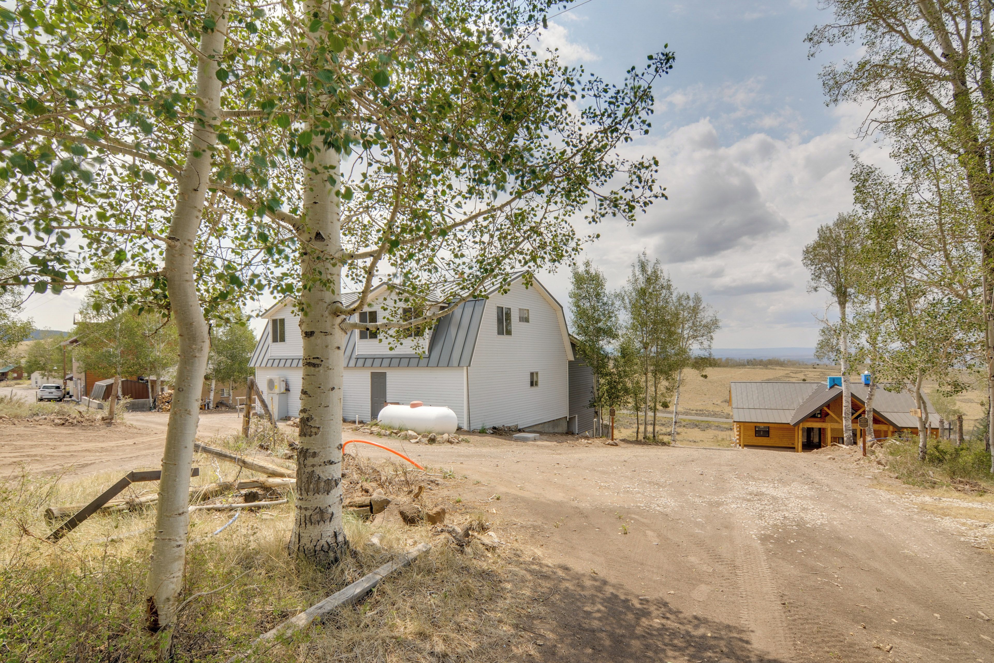 A rural property with a large house, a smaller cabin, and a dirt road.