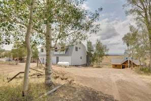 A rural property with a large house, a smaller cabin, and a dirt road.