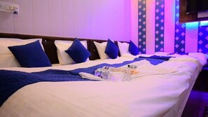 A hotel room with a bed, pillows, a blanket, and a bottle. - Siya Ram Guest House (Ayodhya)