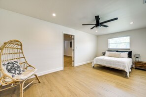 A bedroom with a bed, a wicker chair, a ceiling fan, and a window. - Modern 2-Unit Combo w/ Pool: 'Naples Hideaway' (Naples)