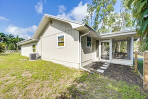 A single-story house with a covered porch, a small patio, and a yard with grass and mulch. - Modern 2-Unit Combo w/ Pool: 'Naples Hideaway' (Naples)