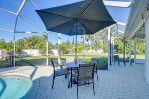 A covered patio with a pool, outdoor seating, and a view of the lawn and trees. - Modern 2-Unit Combo w/ Pool: 'Naples Hideaway' (Naples)