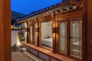 A traditional Japanese-style room with sliding doors, a bed, and a small garden area. - Private Hanok in Ikseon-dong · Jacuzzi & Courtyard · Sleeps up to 10 (종로구)