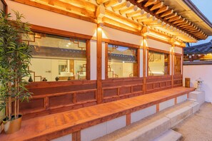 En traditionell byggnad i trä med en överbyggd veranda och trappsteg som leder upp till en entré.