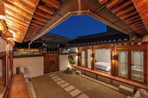 Ein traditioneller japanischer Raum mit Tatami-Bodenbelag, Shoji-Schirm und Holzbalkendecke.