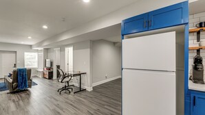 A spacious living area with a large white refrigerator, blue cabinets, and a wooden floor. - 8 Mi to Nissan Stadium & Broadway! (Nashville)