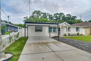 A residential property with a covered patio, a white fence, and a lawn. - Sleek & Central! Safety Harbor Home Near Beaches (Safety Harbor)