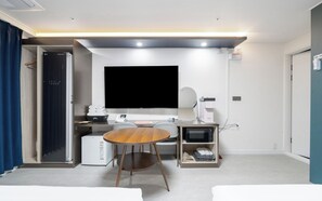 A hotel room with a flat-screen TV, a desk with a computer, a coffee machine, and a microwave. - Brown Dot Hotel Daecheon Beach Boryeong (Boryeong)