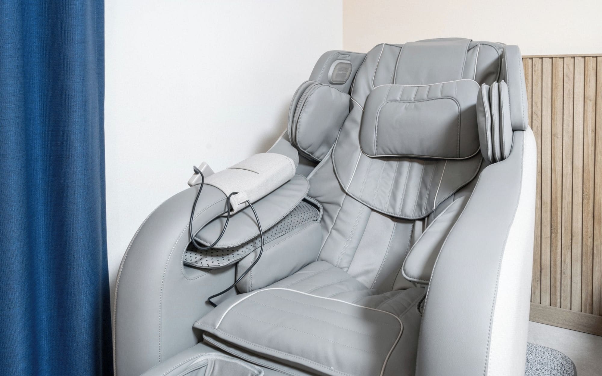A massage chair with a headrest, footrest, and a control panel.